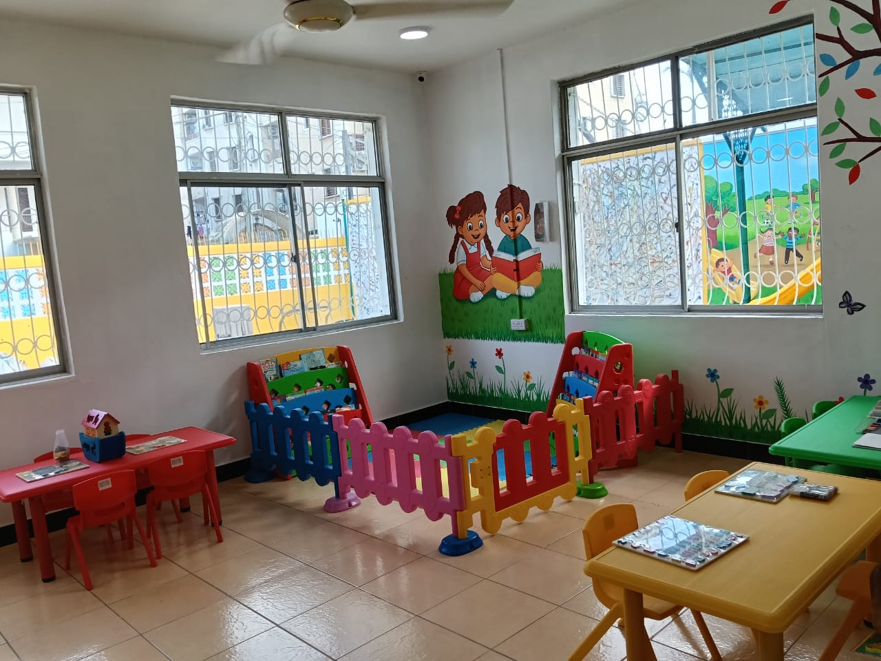 Bright classroom with play pens and mural